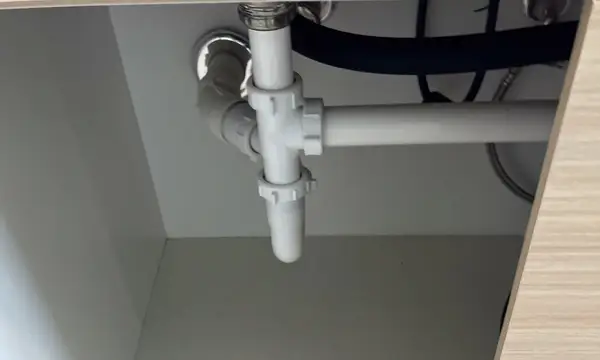 Plastic waste pipework under a kitchen sink