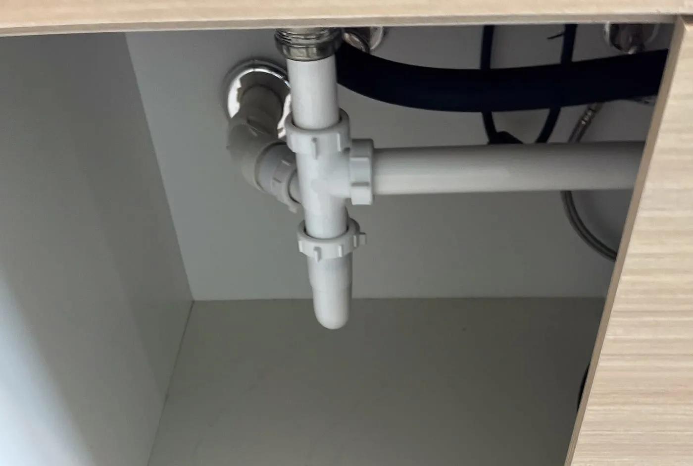 Plastic waste pipework under a kitchen sink