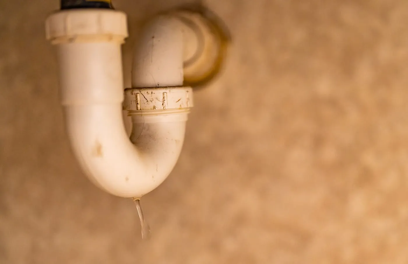 Water dripping from the trap under a bathroom sink