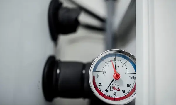A heating system pressure and temperature gauge on a pipe