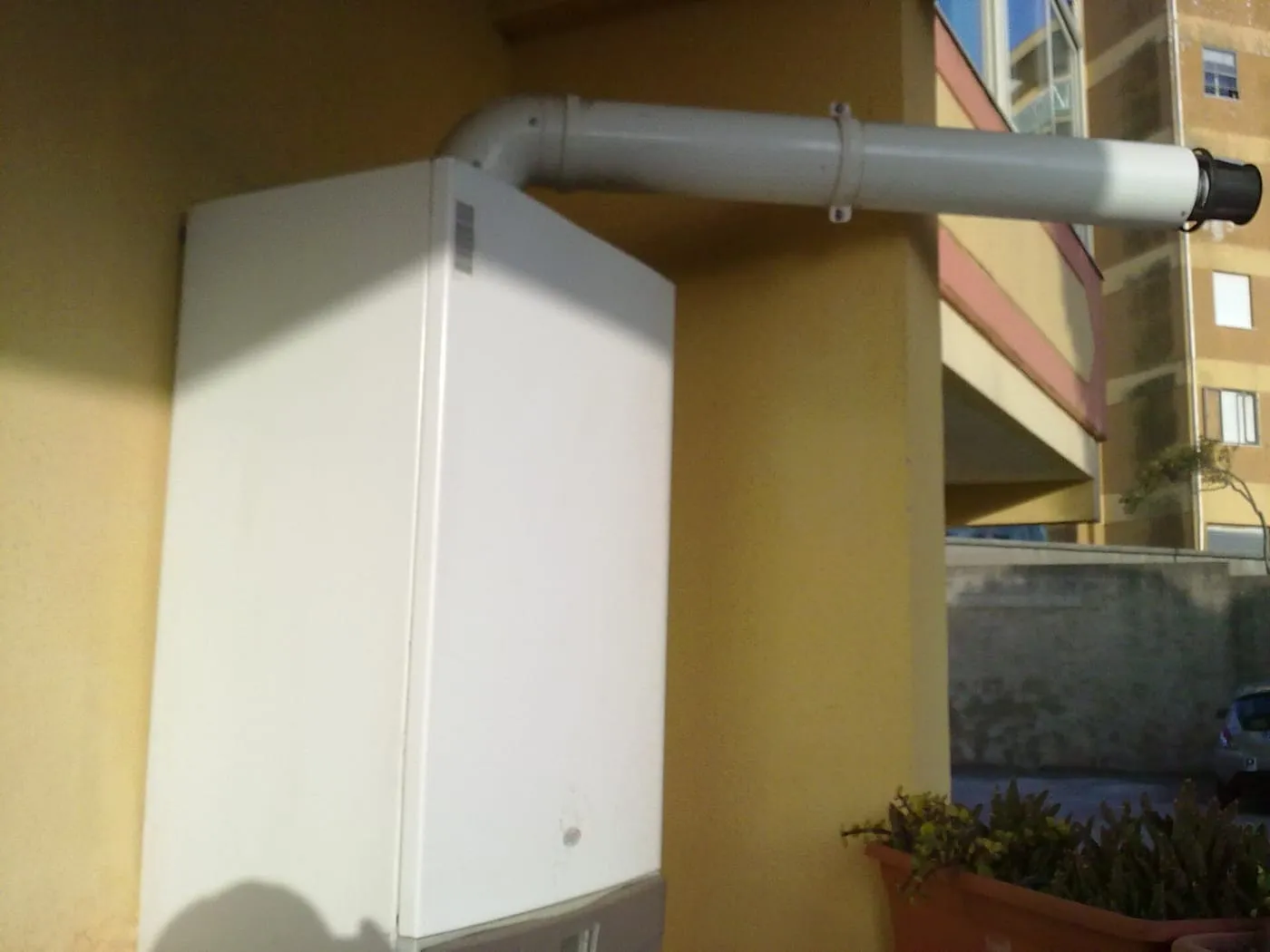 A white wall-mounted gas boiler with its flue pipe