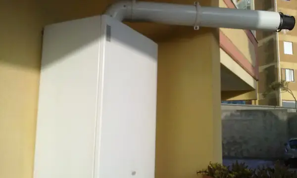 A white wall-mounted gas boiler with its flue pipe