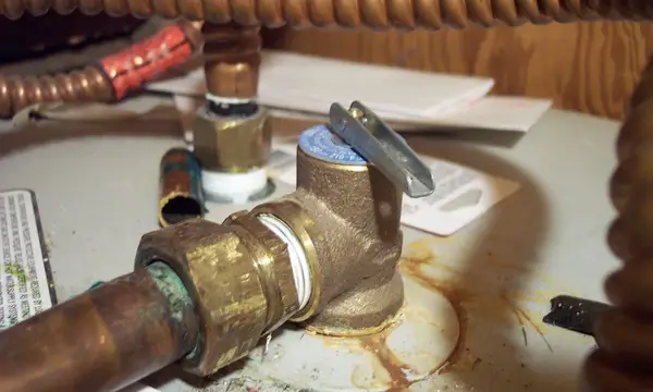 A brass pressure relief valve fitted to copper pipework on a water heater