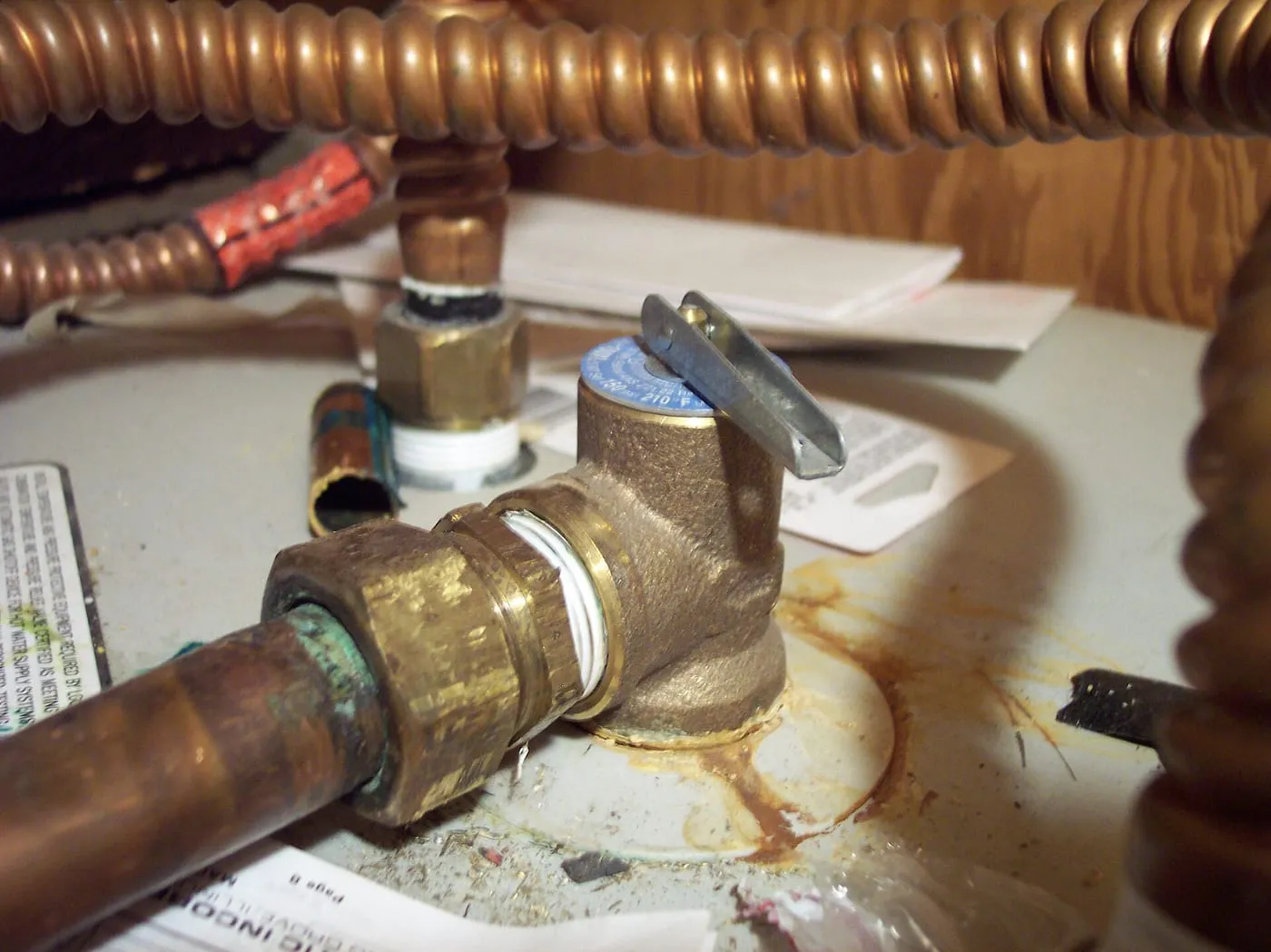 A brass pressure relief valve fitted to copper pipework on a water heater