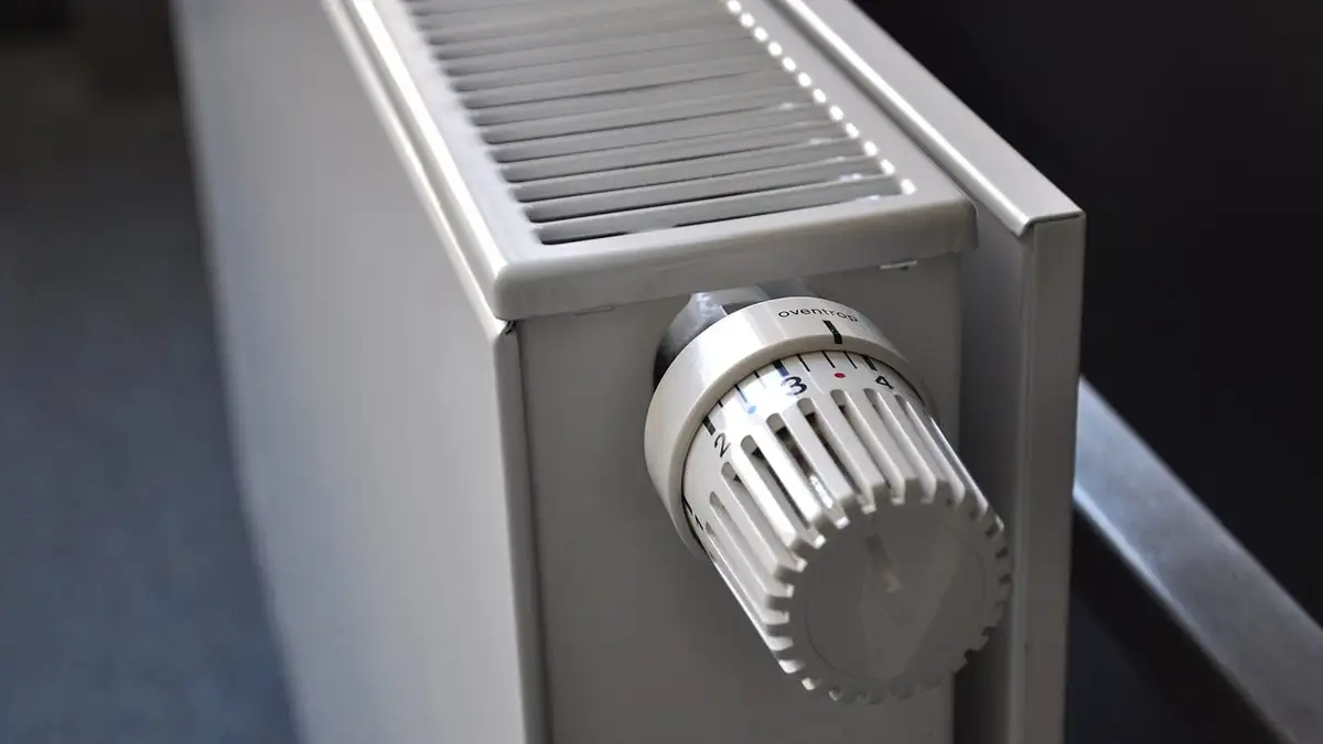 A thermostatic valve on the side of a white panel radiator