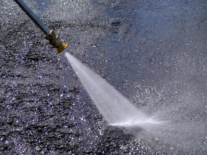 A high-pressure water jet spraying from a nozzle
