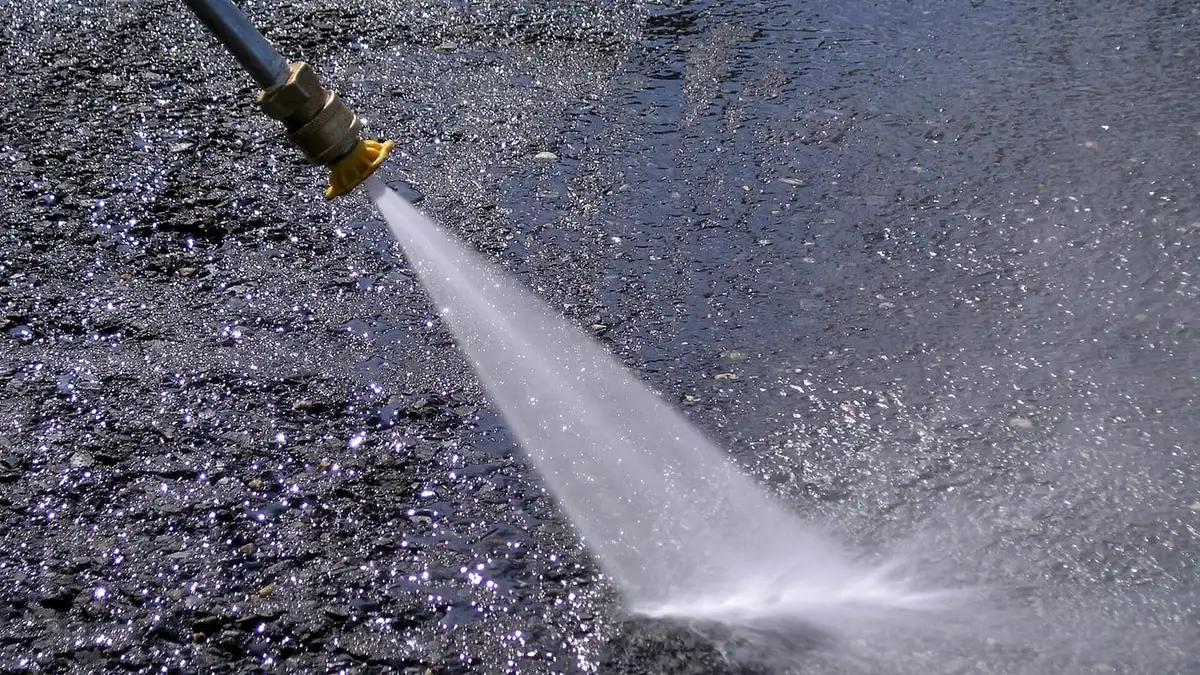 A high-pressure water jet spraying from a nozzle