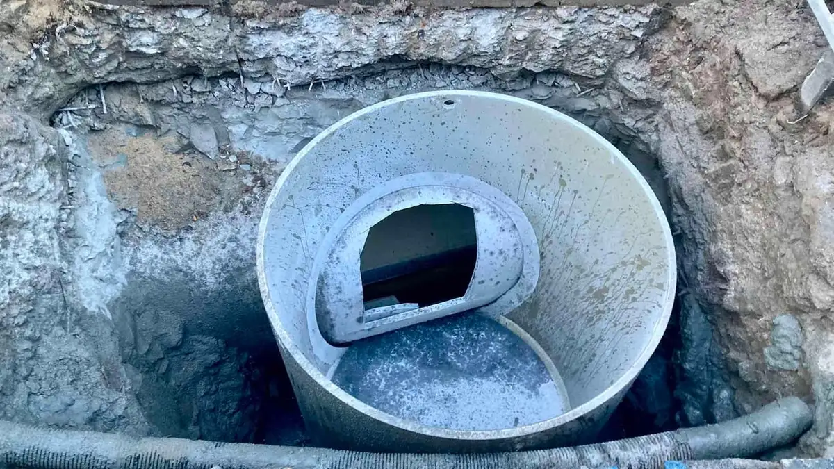 An excavated drain with a new liner pipe fitted inside the old sewer