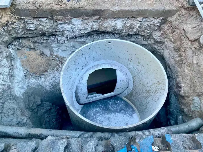 An excavated drain with a new liner pipe fitted inside the old sewer