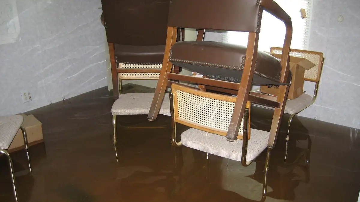 Chairs standing in floodwater inside an office