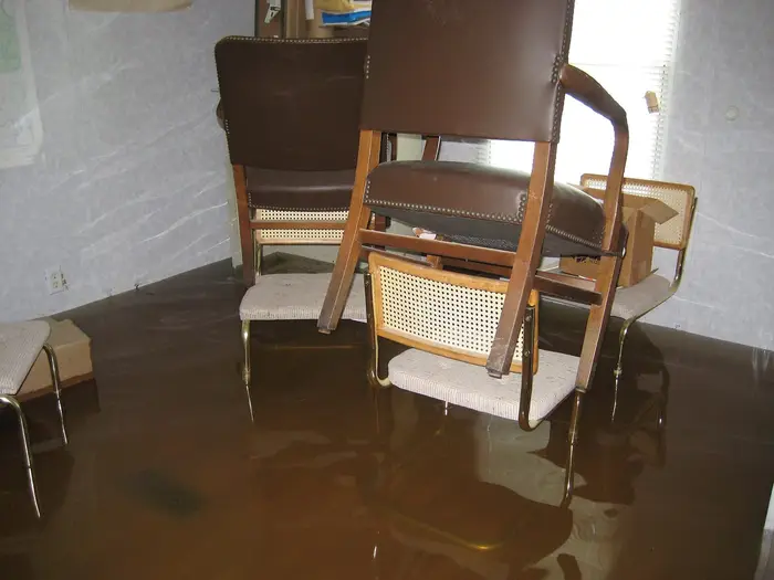 Chairs standing in floodwater inside an office