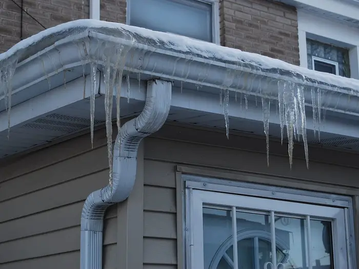 Icicles hanging from a gutter and downpipe after a freeze