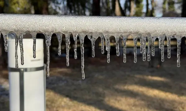 Icicles hanging from an outdoor pipe after freezing rain