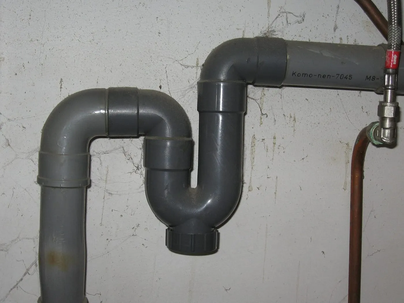 Grey plastic trap under a sink