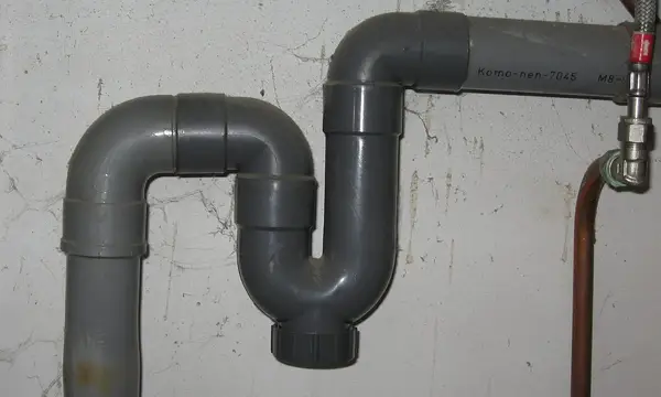 Grey plastic trap under a sink