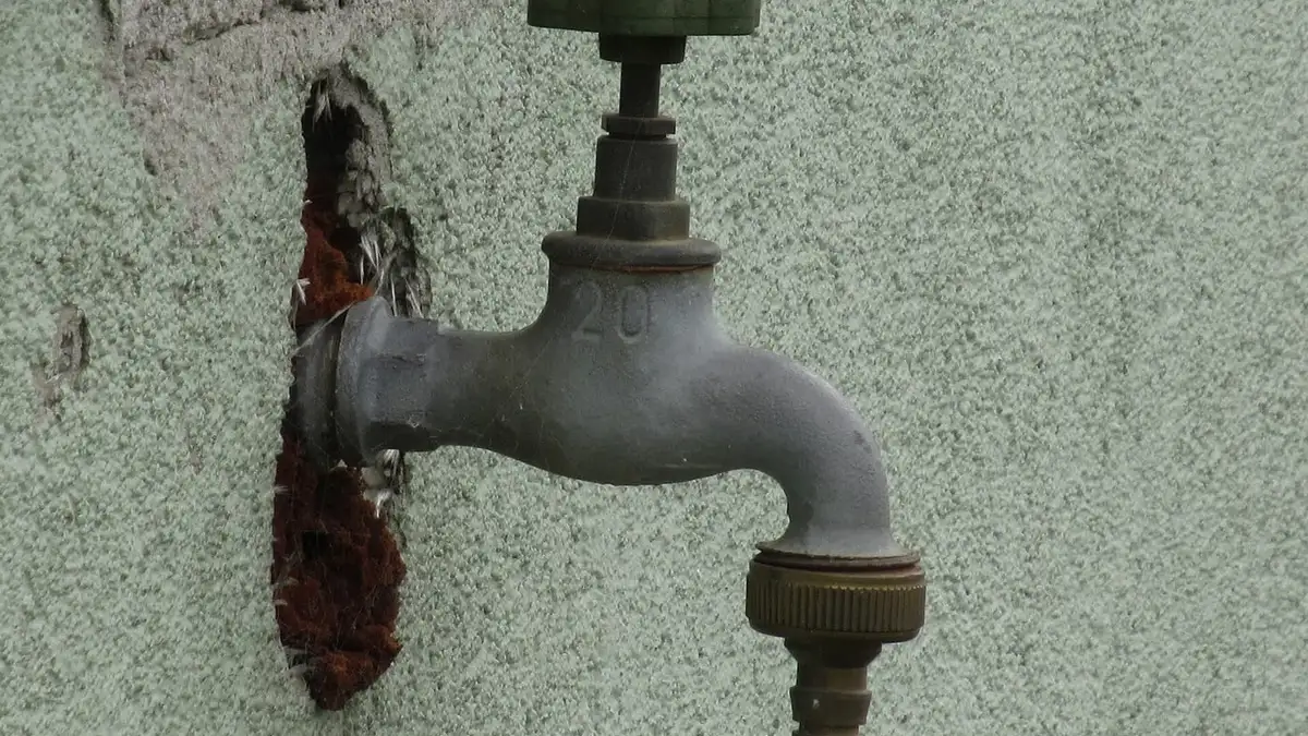 An old metal tap on an outside wall