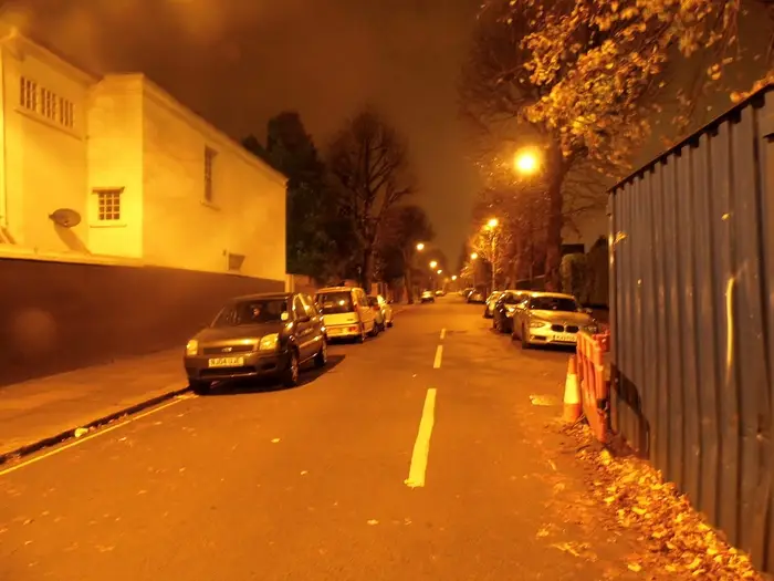 A residential street in Ealing at night under orange street lights