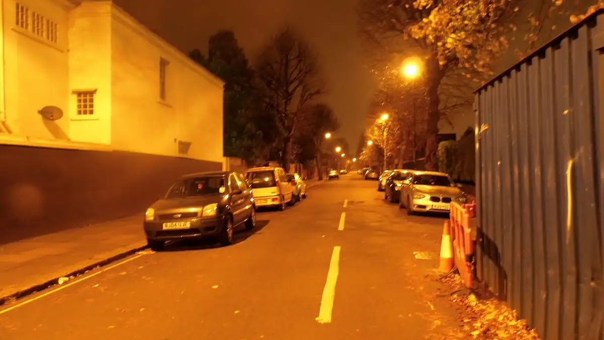 A residential street in Ealing at night under orange street lights