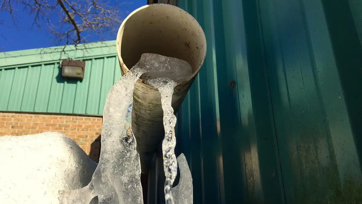 Ice frozen at the outlet of a pipe in winter