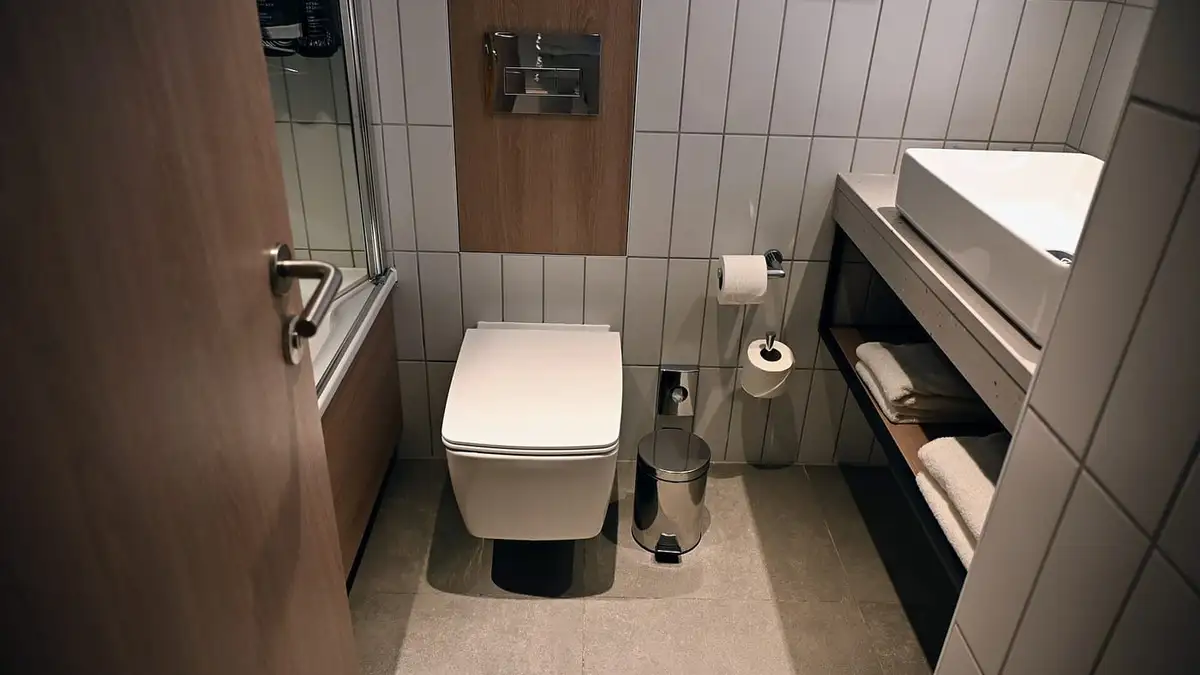 A compact toilet room with a wall-hung toilet beside a vanity unit