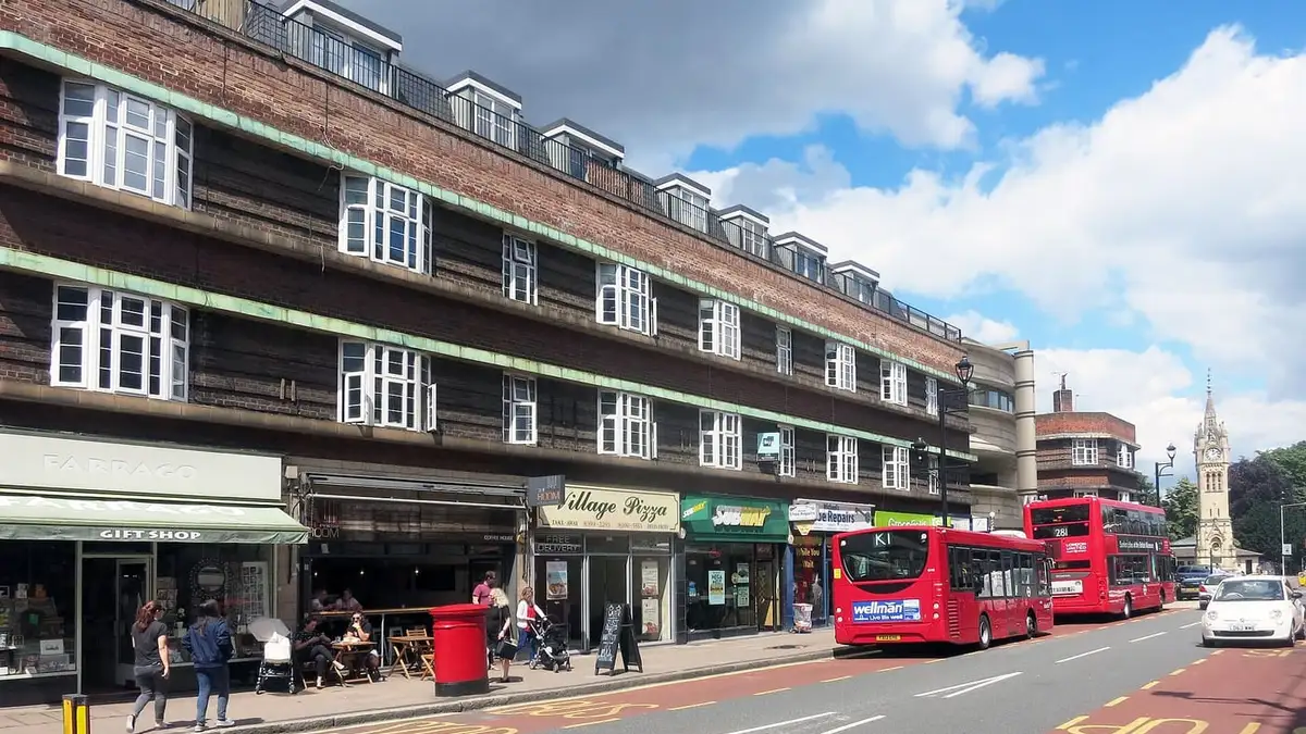 Shops on Claremont Road in Surbiton town centre, with the clock tower beyond