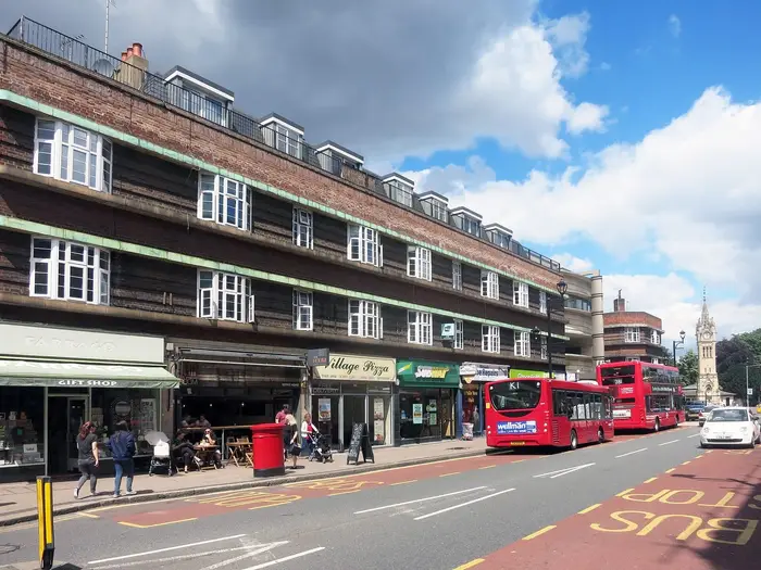 Shops on Claremont Road in Surbiton town centre, with the clock tower beyond