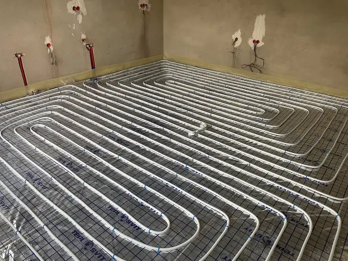 Underfloor heating pipes laid in loops across a floor before screeding