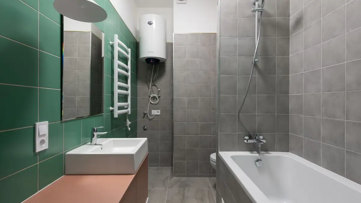 A modern bathroom with a white hot water cylinder mounted high on the wall