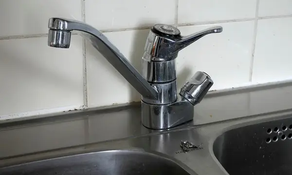 A chrome single-lever mixer tap over a stainless steel kitchen sink