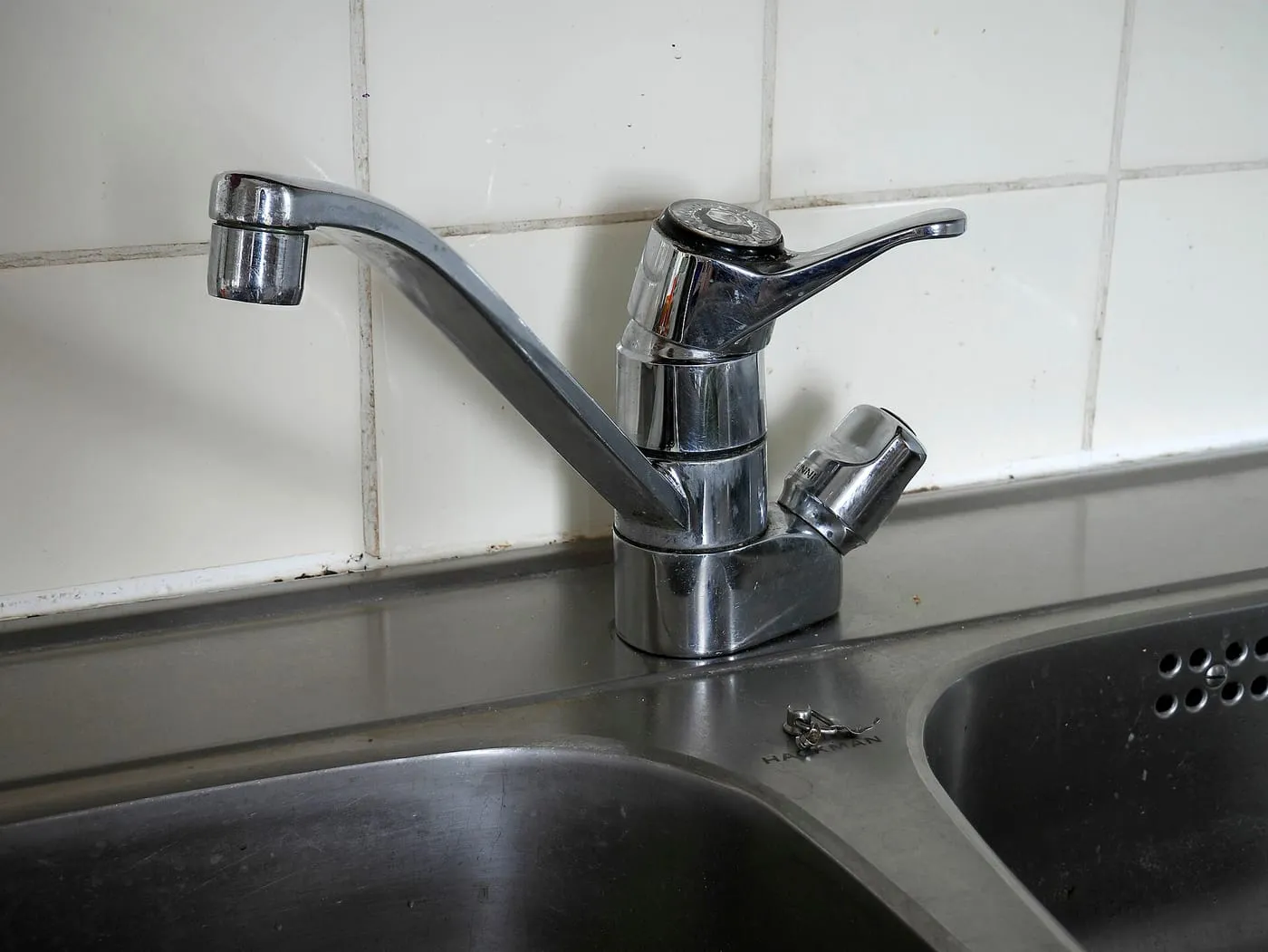 A chrome single-lever mixer tap over a stainless steel kitchen sink