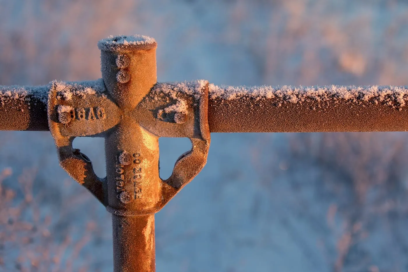Frost on a metal pipe fitting at sunrise